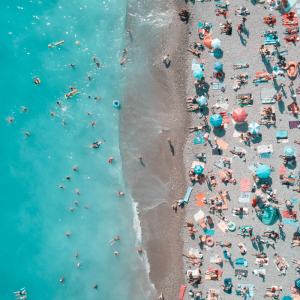 crowded white sand beach with crystal blue ocean water