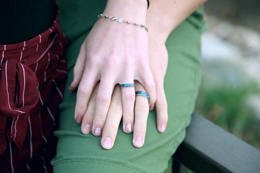 photo of two hands with matching turquois engagement rings