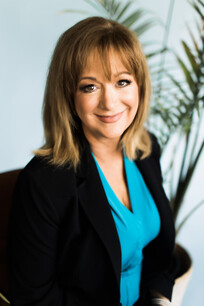 Smiling woman wearing blue shirt and black blazer