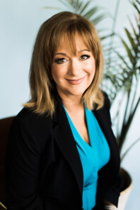 Smiling woman wearing blue shirt with black blazer