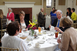 four people seated at a formal dining table in business attire