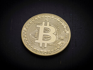 photo of a bitcoin on a black felt surface