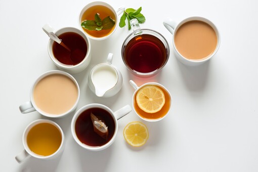 photo shot looking down from above at many different kinds of cups filled with different kinds of tea