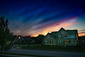 suburban family home at sunset with a divided sky framing the house with light