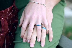photo: two hands on top of each other with matching turquois rings
