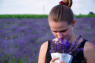 woman enjoying the scent of lavender flowers