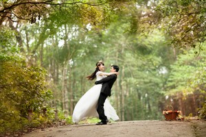 bride and groom in marital bliss embracing eat other in a green park
