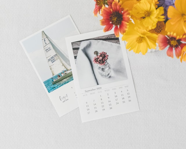 photo: calander on a table with a note and flowers, looks like a reminder