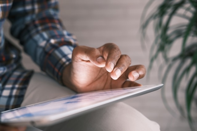 photo: hand hovering over a tablet ready to swipe or touch