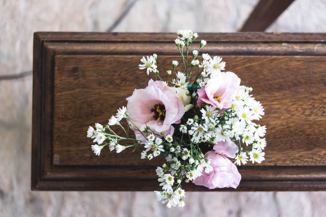 photo: pink and white flowers on a wooden casket shot from above