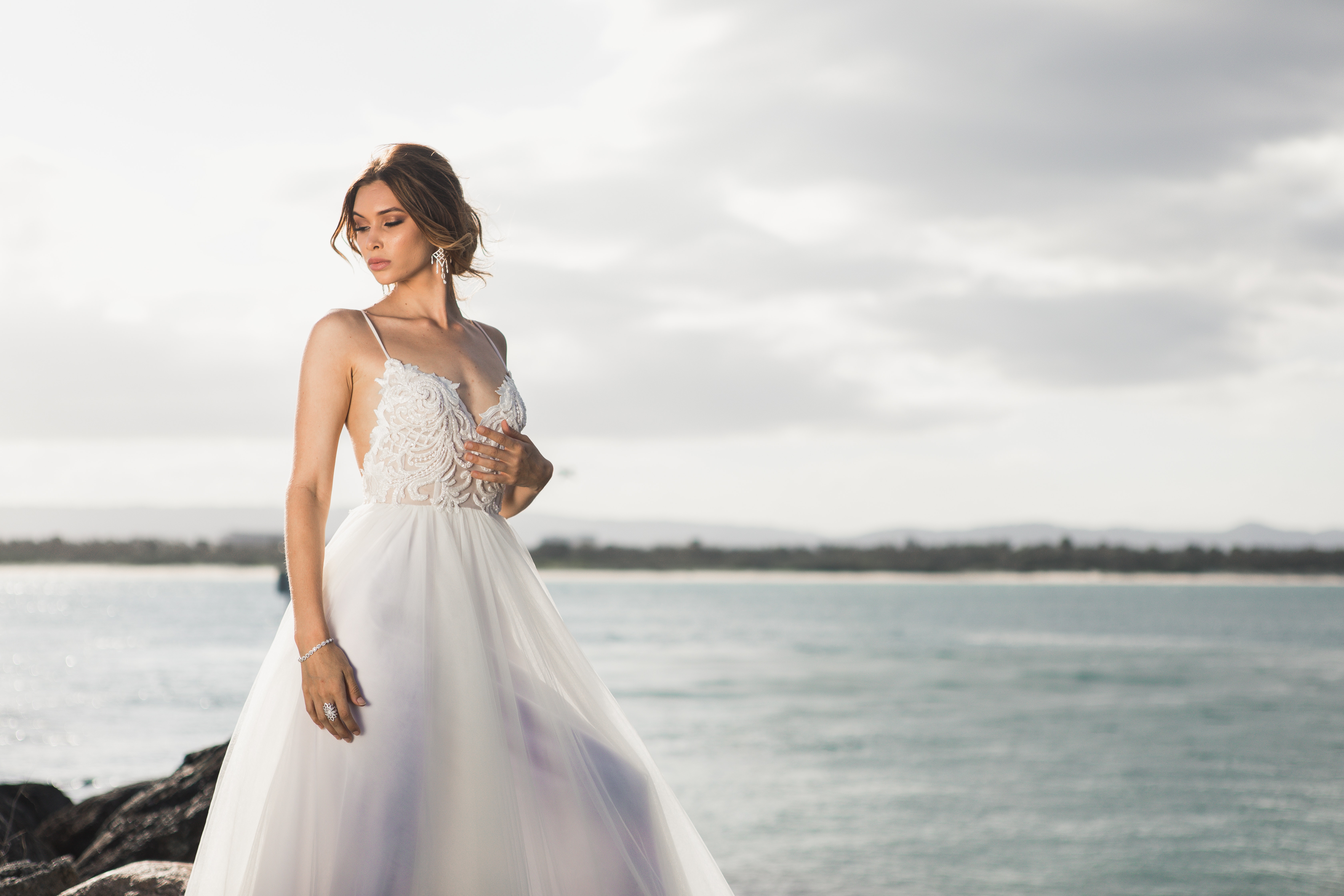 elegant bride standing at the edge of a body of water