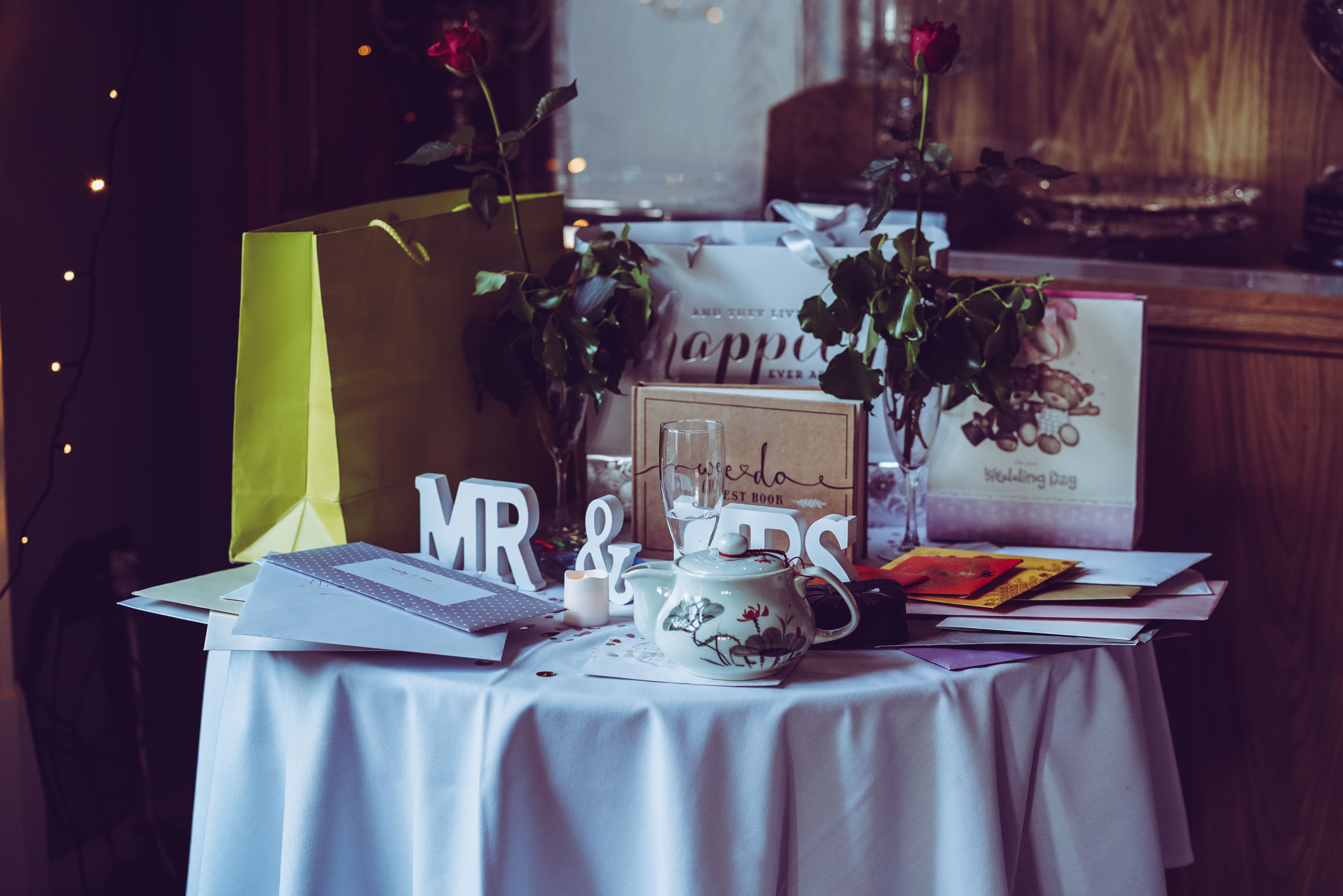 white tablecloth gift table at a wedding reception, with gift bags and cards