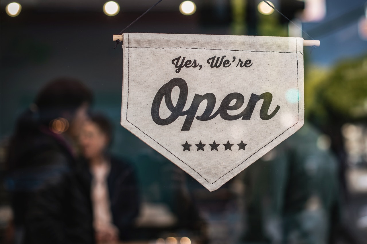 open sign displayed in the front window of a business post pandemic